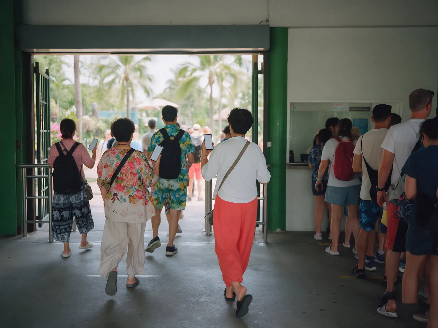 Visitors walking in through the entrance gate of a park